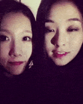 two women are standing next to each other and smiling at the camera .