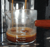 a measuring cup that says bcnmviku is filled with liquid