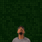 a man with a beard and glasses looks up at the number 24