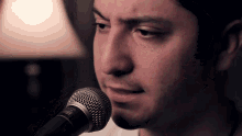 a man singing into a shure microphone in a dark room