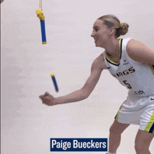 a female basketball player with the name paige bueckers on the bottom
