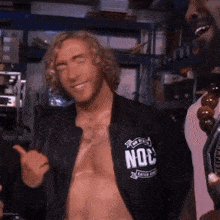 a shirtless man is wearing a black jacket with the word noc on it