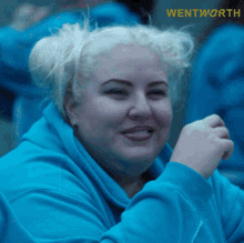 a woman in a blue sweatshirt with the word wentworth on the bottom right