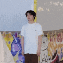a man is standing in front of a wall with graffiti on it .