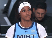 a female basketball player wearing a blue mist jersey