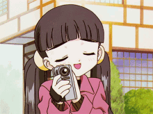 a girl in a pink jacket is taking a picture with her eyes closed
