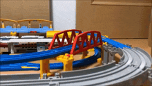 a toy train set with a red bridge and a blue track