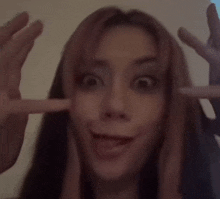 a woman is making a funny face with her hands