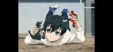 a young boy is laying on the ground holding two toys