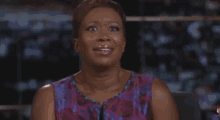 a woman in a purple dress is smiling and crying