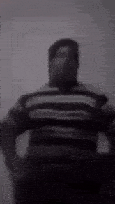 a black and white photo of a man in a striped shirt .