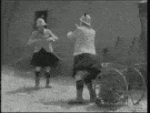 a black and white photo of two men standing next to each other with gifrun.com written on the bottom