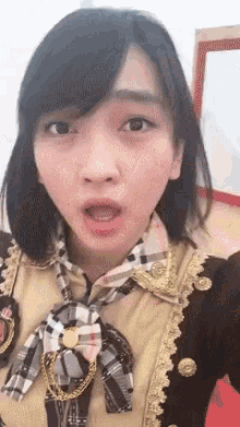 a woman with braces on her teeth is wearing a plaid scarf around her neck