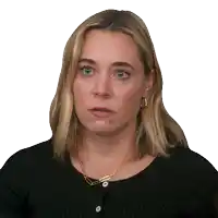 a woman with blonde hair and blue eyes is wearing a black sweater and a gold necklace