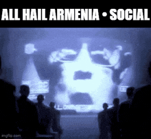 a group of people looking at a screen that says all hail armenia