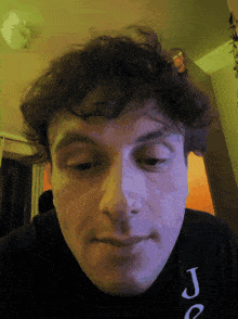 a close up of a man 's face with a shirt that says joe on it