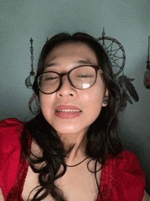 a girl wearing glasses and a red shirt looks at the camera