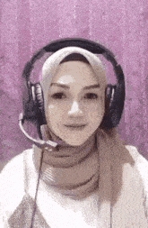 a woman wearing a hijab and headphones with a microphone on her head .