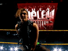 a woman in a wrestling ring with the word nxt on the bottom
