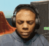 a man wearing headphones looks at the camera with a green sign that says 1.50 on it