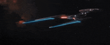 a futuristic space ship is flying through space with glowing lights coming out of it .