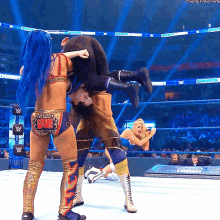 a female wrestler is holding a man upside down in a wrestling ring
