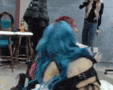 a woman with blue hair is hugging a woman with pink hair