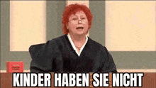a judge with red hair and glasses is sitting in a courtroom with a sign that says `` kinder haben sie nicht '' .