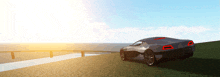 a car is parked on a grassy hill near the ocean