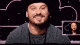 a man with a beard wearing a hat and a lanyard