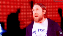 a man with a beard is wearing a yes t-shirt
