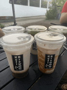 several cups of kb brew on a table outside