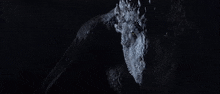 a close up of a dragon in the dark looking at the camera .