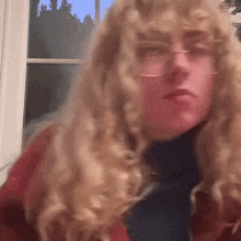 a woman with curly blonde hair wearing glasses