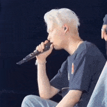 a man is singing into a microphone while wearing headphones .