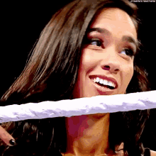 a woman is smiling while holding a rope around her neck
