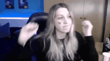a woman with long blonde hair is sitting in a chair in front of a computer screen .