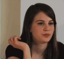 a close up of a woman 's face with her hand on her face