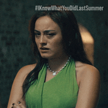 a woman wearing a green dress and a pearl necklace has a #iknowwhatyou did last summer sticker on her face