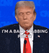 donald trump is wearing a suit and tie and talking into a microphone while making a face .