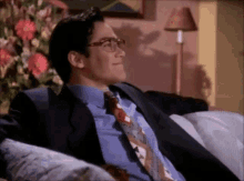a man in a suit and tie sitting on a couch
