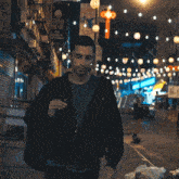 a man walking down a street with a sign that says ' hong kong '