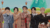 a group of young men are posing for a picture and one of them is wearing a pink plaid shirt