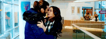 a man and woman are kissing in a hallway .