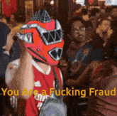 a person wearing a red helmet with the words you are a fucking fraud on it