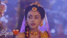 a close up of a woman wearing a crown and earrings with a heart .