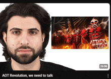 a man with a beard is next to a poster of attack on titan