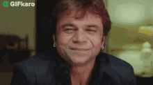 a man with earrings on his ears is smiling and making a face .