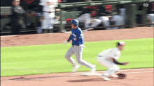 a baseball player in a blue uniform runs towards the base