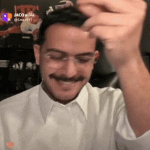 a man wearing glasses and a white shirt with the name jaco on the bottom right corner